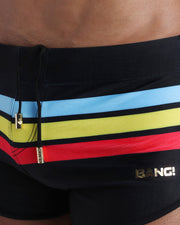 Close-up view of men’s summer swimwear by BANG! clothing brand, showing black cord with custom branded golden cord ends, and matching custom eyelet trims in gold.