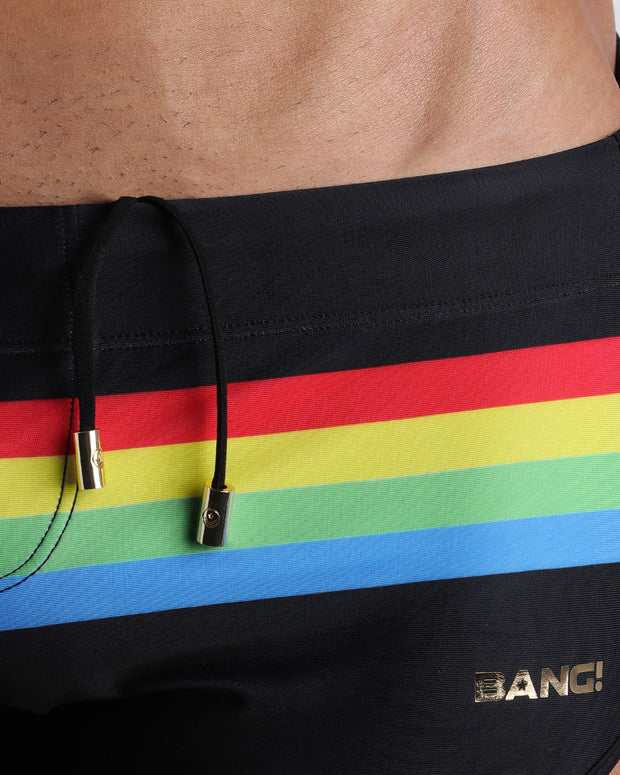 Close-up view of inseam and details of FOREVER STRIPES VOL 1 swimsuit for men, with black cord and custom branded golden cord-ends, and matching custom eyelet trims in gold.