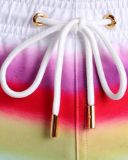 Close-up view of men’s summer shorts with a rainbow, showing white cord with custom branded golden cord ends, and matching custom eyelet trims in gold.