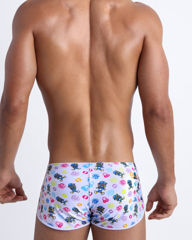 Back view of model wearing the HEY MISTER TJ (POOLSIDE MIX) Men’s beach swim shorts by BANG! with clubbing and disc-jockey details in dark colors.