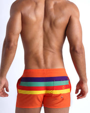 Back side of the Stripe'A'Pose REMIX men’s beach trunks in orange with colored bands in violet, green, red and yellow by Bang! Miami.