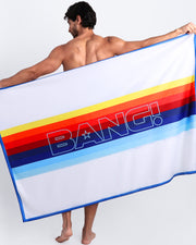 View of sexy male model showing the STRIPES ON 45 unisex lightweight towel in white with rainbow colored bands by Bang! 80s California Surfer Roller Skating culture.