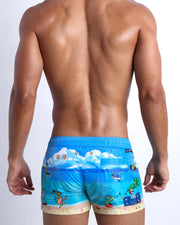 Male model's back view showing the 8-BIT WILD BEACH PARTY swimsuit shorts for men with vintage  sprite graphics of  Atari video game, Nintendo, Sega, Commodore 64