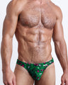 Front view of the CAMO CHAMELEON men’s bikini-style bottoms in a forest green color with white and pink camo print by the Bang! brand of men's beachwear from Miami.