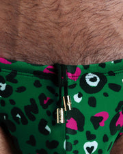 Close-up view of the CAMO CHAMELEON men’s summer shorts by BANG! clothing brand, showing black cord with custom branded golden cord ends, and matching custom eyelet trims in gold.