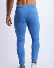 Back view of men's high quality outdoor track pants in a solid denim blue color with back zippered pocket. Suitable for daily, running, working out, exercise and hanging out in Winter.