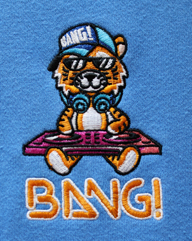 Close-up image of the embroidered BANG! Logo featuring the brands signature MISTER TJ character with clubbing and disc-jockey details in bright colors.