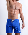 Frontal view of sexy model wearing the CLUB BLUE men’s all-purpose swimwear bottoms in a royal blue color by the Bang! brand of men's beachwear from Miami.