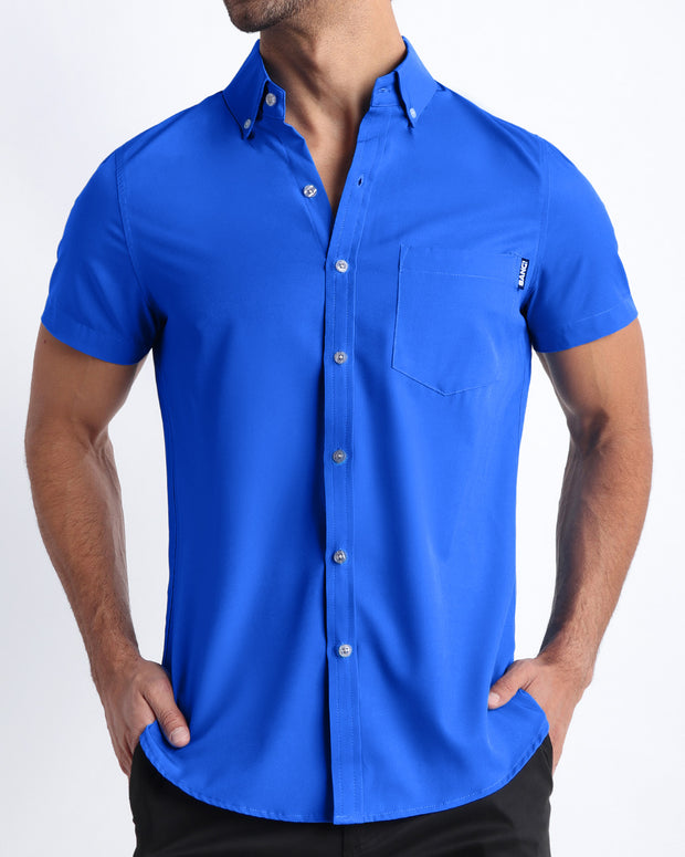 Front view of a sexy male model wearing CLUB BLUE mens short-sleeve stretch shirt in a bright blue color by the Bang! brand of men&