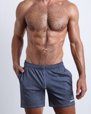 Frontal view of male model wearing the COMPOUND BLUE jogger shorts in a heathered dark blue quick-dry by the Bang! brand of men's beachwear from Miami.