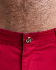 Close up view of cotton fabric chino street shorts with custom engraved front tack button in golden finish by BANG! men's clothing brand.