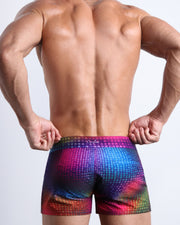 Back view of male model wearing the CONFESSIONS ON A SAND FLOOR beach shorts for men by BANG! Miami in multiple colors Disco Ball design.