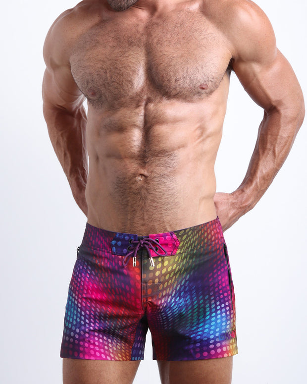 Frontal view of model wearing the CONFESSIONS ON A SAND FLOOR men’s mini swimming shorts in multiple colors disco ball print by the Bang! menswear brand.