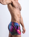 Left side view of men’s shorter leg length shorts in a pop color with disco ball print and a back pocket with the phrase 