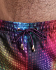 Close-up view of the CONFESSIONS ON A SAND FLOOR men’s summer shorts, showing dark purple cord with custom branded golden cord ends, and matching custom eyelet trims in gold.