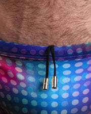 Close-up view of the CONFESSIONS ON A SAND FLOOR men’s drawstring briefs showing white cord with custom branded golden cord ends, and matching custom eyelet trims in gold.