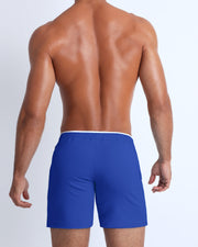 Back view of the men's above-knees length fitness workout shorts in a royal blue color by BANG! menswear Miami.