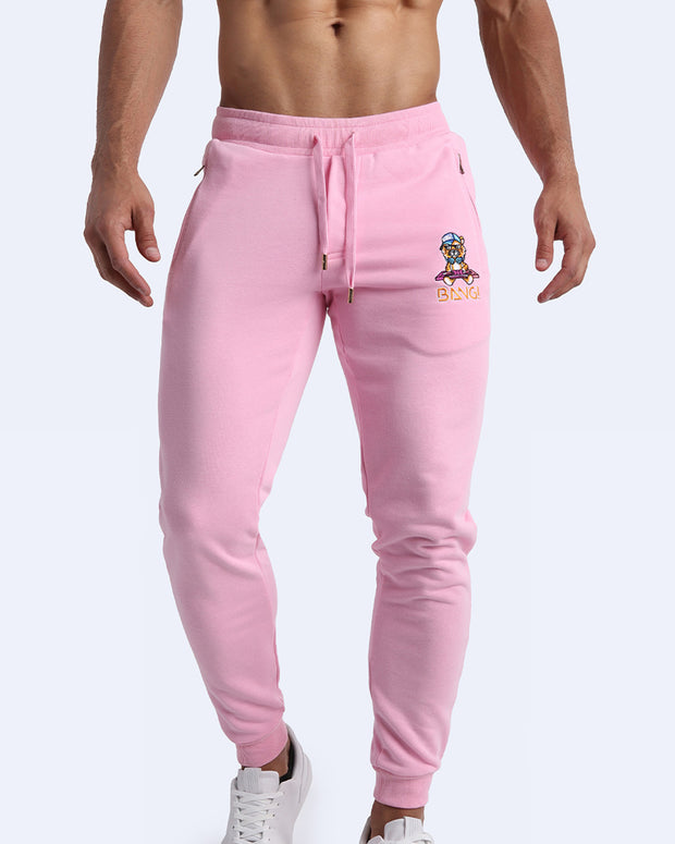 Frontal view of male model wearing the BANG! Clothes EURO PINK Tracksuit Pants with frontal drawstring closure. This athletic jogger has an embroidered Bang! Logo with the signature Mister TJ tiger. 