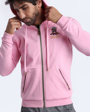 Frontal view of male model wearing the BANG! Clothes EURO PINK Tracksuit Hoodie Jacket with frontal zipper closure. This long-sleeve jacket has an embroidered Bang! Logo with the signature Mister TJ tiger. 