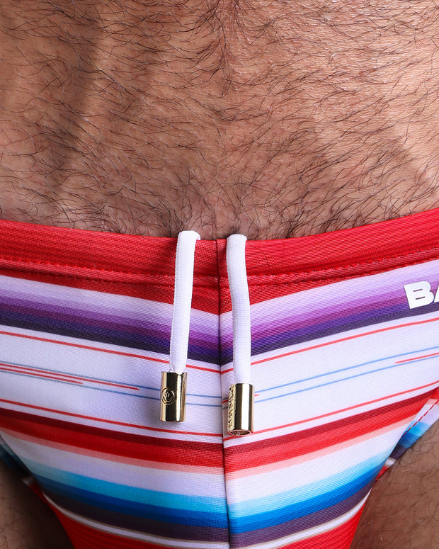 Close-up view of the FAWCETT SARAPE men’s summer shorts by BANG! clothing brand, showing white cord with custom branded golden cord ends, and matching custom eyelet trims in gold.