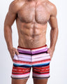 Front view of model wearing the FAWCETT SARAPE men’s beach tailored shorts in white with red, blue, purple Mexican blanket desings by the Bang! Clothes brand of men's beachwear from Miami.