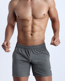 Frontal view of male model wearing the FIRM GREY jogger shorts in a solid grey by the Bang! brand of men's beachwear from Miami.