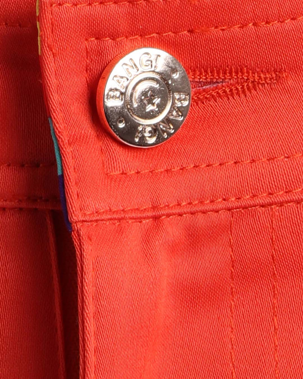 Close up view of cotton fabric chino street shorts with custom engraved front tack button in golden finish by BANG! men's clothing brand