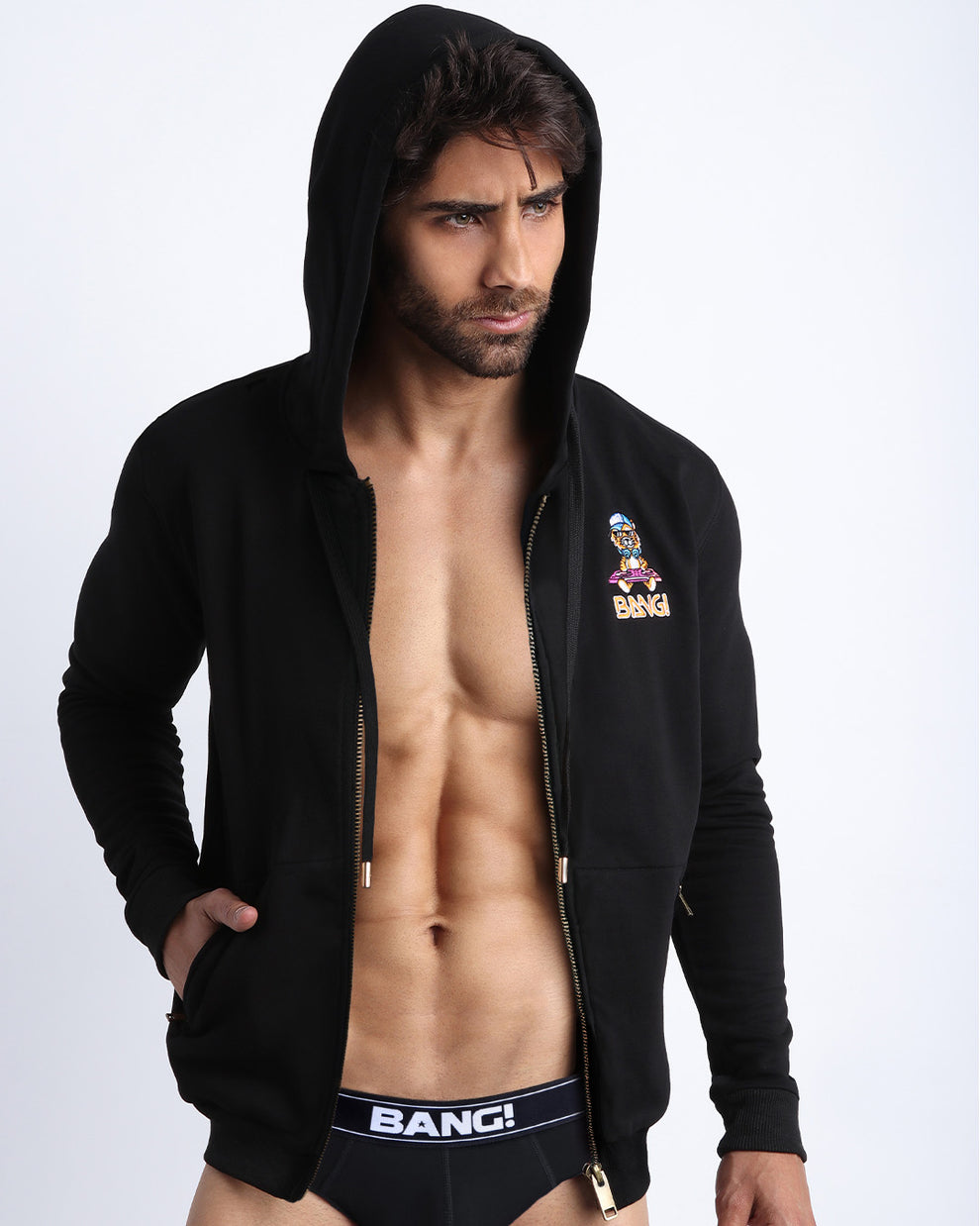 Sexy male model wearing the perfect BLACK men's zippered hoodie to keep you warm during chilly fall weather. With it's soft, warm fabric and it's two front pockets and hood with adjustable drawcord. 