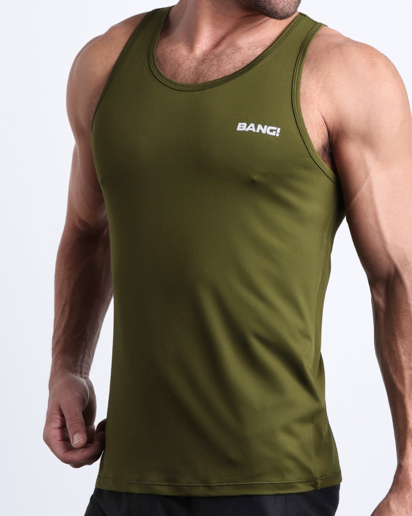 Side view of male model wearing the GREENSPIRATION in a solid dark green color gym tank top for men by the Bang! brand of men's beachwear from Miami.