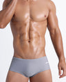 Frontal view of a sexy male model wearing men’s swimsuit in gray color by the Bang! Menswear brand from Miami.