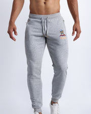Frontal view of male model wearing the BANG! Clothes GREY Tracksuit Pants with frontal drawstring closure. This athletic jogger has an embroidered Bang! Logo with the signature Mister TJ tiger. 