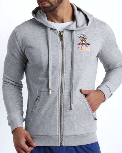 Frontal view of male model wearing the BANG! Clothes GREY Tracksuit Hoodie Jacket with frontal zipper closure. This long-sleeve jacket has an embroidered Bang! Logo with the signature Mister TJ tiger. 