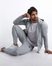 Sexy male model wearing the perfect GREY color men's zippered hoodie to keep you warm during chilly fall weather. With it's soft, warm fabric and it's two front zipper pockets and hood with adjustable drawcord. 