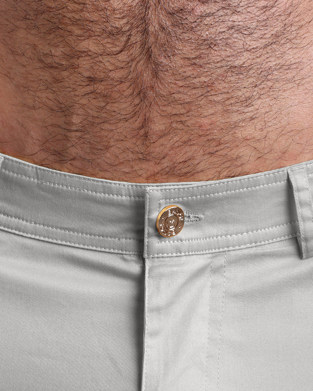 Close up view of cotton fabric chino street shorts with custom engraved front tack button in golden finish by BANG! men&