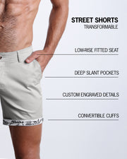 Men tailored fit chino shorts in GREYS JONES by Bang! Keeps you feeling comfortable and looking sharp all. Classic chino shorts for men in a cotton blend from Bang! Clothing from Miami. Features two front pockets and custom engraved button front closure with zip fly. Can roll-up cuffs for shorter length and showing internal print. Or hem down for a mid-thigh length and full-solid grey color showing.