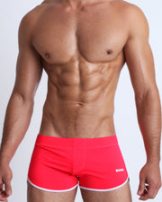 Frontal view of a sexy male model wearing men’s swimsuit in red by the Bang! Menswear brand from Miami.