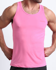 Frontal view of male model wearing the LA BEACH EN ROSE in a pink men's gym tank top by the Bang! brand of men's beachwear from Miami.