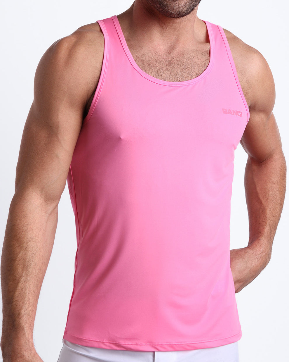 Frontal view of male model wearing the LA BEACH EN ROSE in a pink men's gym tank top by the Bang! brand of men's beachwear from Miami.