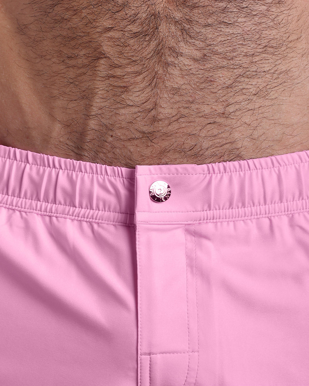 Close-up view of the men’s summer mini shorts, showing custom branded metal button in gold.