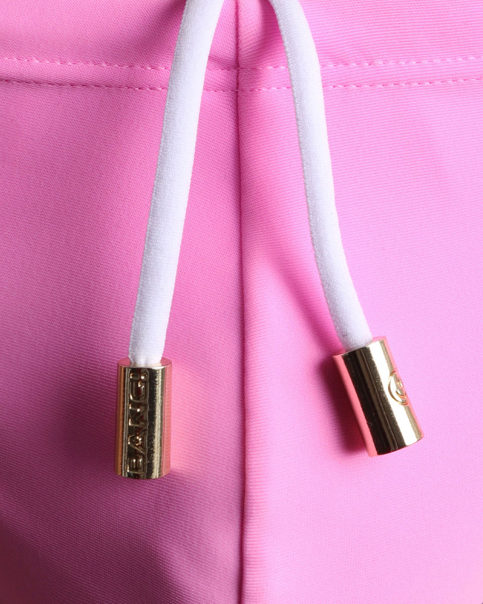 Close-up view of men’s summer swim mini brief by BANG! clothing brand, showing white cord with custom branded golden cord ends, and matching custom eyelet trims in gold.