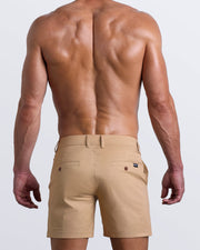 Back view of a model wearing woven twill cotton chino shorts in a khaki light brown color for men by BANG! Clothing brand of Miami