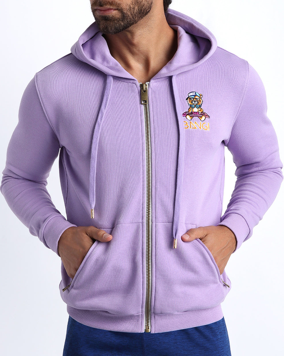 Frontal view of male model wearing the BANG! Clothes METRO PURPLE Tracksuit Hoodie Jacket with frontal zipper closure. This long-sleeve jacket has an embroidered Bang! Logo with the signature Mister TJ tiger. 
