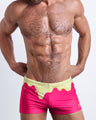 Frontal view of a sexy male model wearing men's swimsuit with mini pockets in MY MILKSHAKE in a bright pink color featuring yellow melting ice cream print designed by the Bang! Menswear brand from Miami.