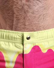 Close-up view of the MY MILKSHAKE men’s beach shorts, showing custom branded metal button in gold by Bang!