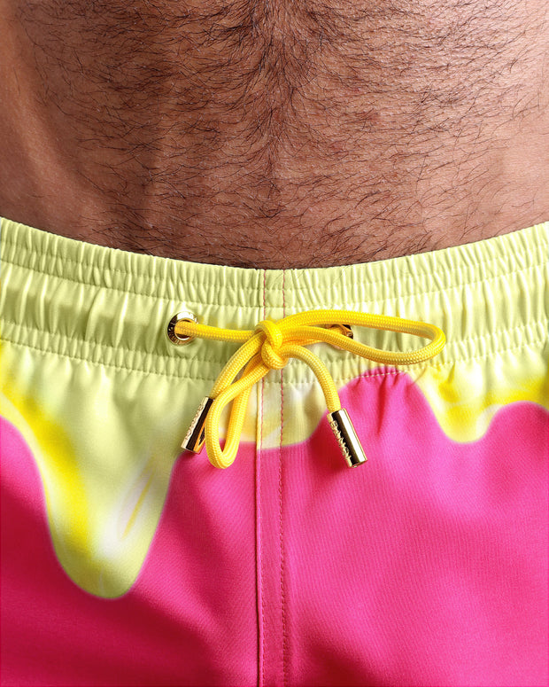 Close-up view of the MY MILKSHAKE men’s summer shorts, showing yellow cord with custom branded golden cord ends, and matching custom eyelet trims in gold.