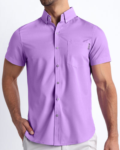 Front view of a sexy male model wearing NEO VIOLET mens short-sleeve stretch shirt in a light purple color by the Bang! brand of men's beachwear from Miami.