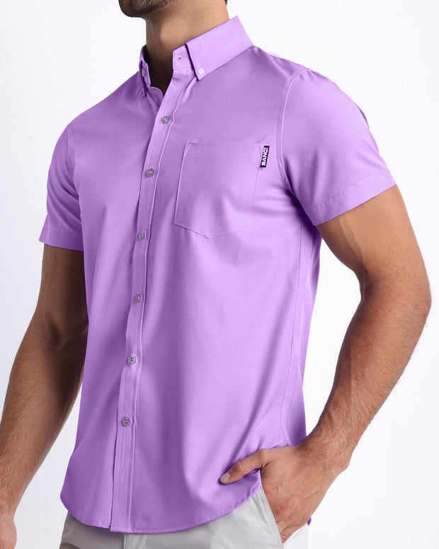 Side view of a masculine model wearing men’s NEO VIOLET Summer button down shirt in a pastel purple color with official logo of BANG! Brand.