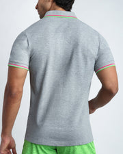 Back view of a sexy model wearing a short-sleeve classic polo shirt for men in a grey color from BANG! Clothing the official brand for menswear.