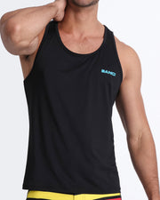 Frontal view of a sexy male model wearing a men’s tank top in a bold black color by the Bang! Menswear brand from Miami.