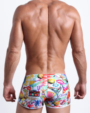 Back view of a model wearing PEOPLE FROM IBIZA men’s beach brief inspired by Ibiza Summer party scene made by the Bang! Miami official brand of men's swimwear.